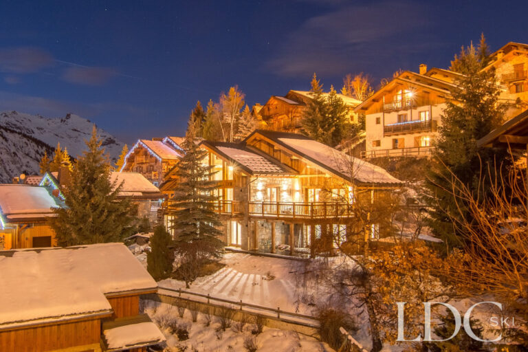 Chalet Astilla illuminated at night in the snowy village of St Martin de Belleville