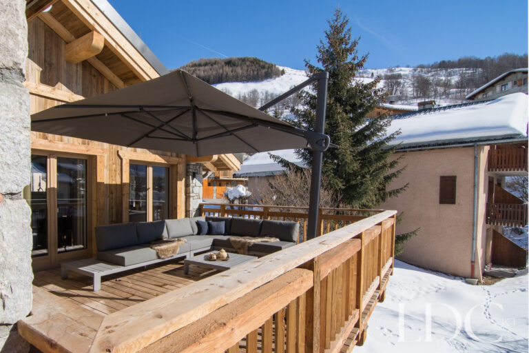 Sunny outdoor terrace at Chalet Astilla with seating and views towards the ski slopes in St Martin de Belleville