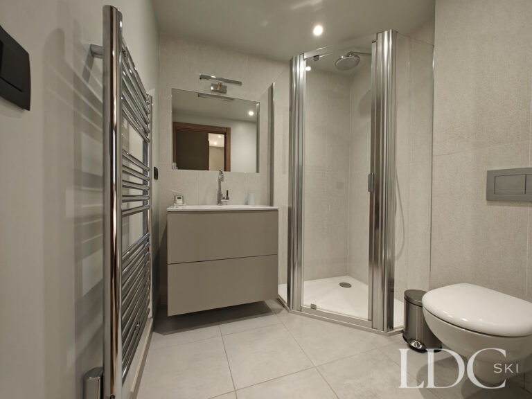 Contemporary bathroom with walk-in shower and stone-effect finishes at Chalet Chardon