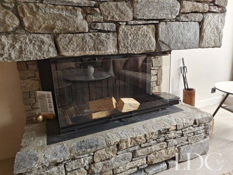 Large stone fireplace in the main living area at Chalet Chardon in St Martin de Belleville