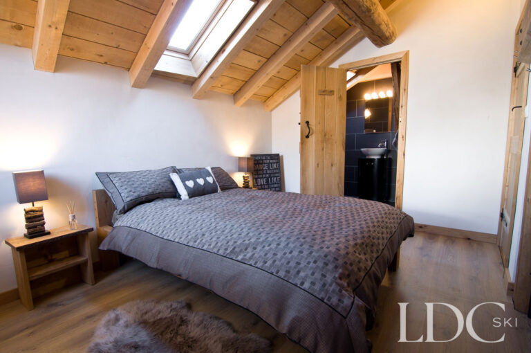 Double bedroom at Chalet Ann with exposed timber beams and roof windows
