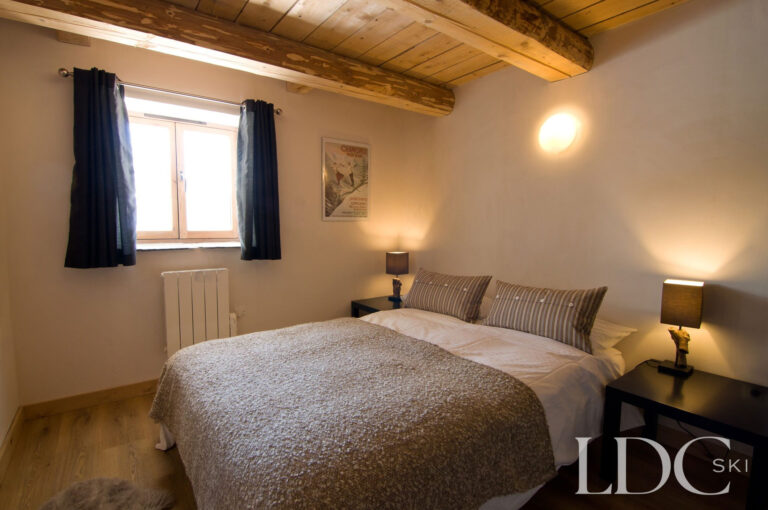 Comfortable double bedroom at Chalet Ann with exposed timber ceiling