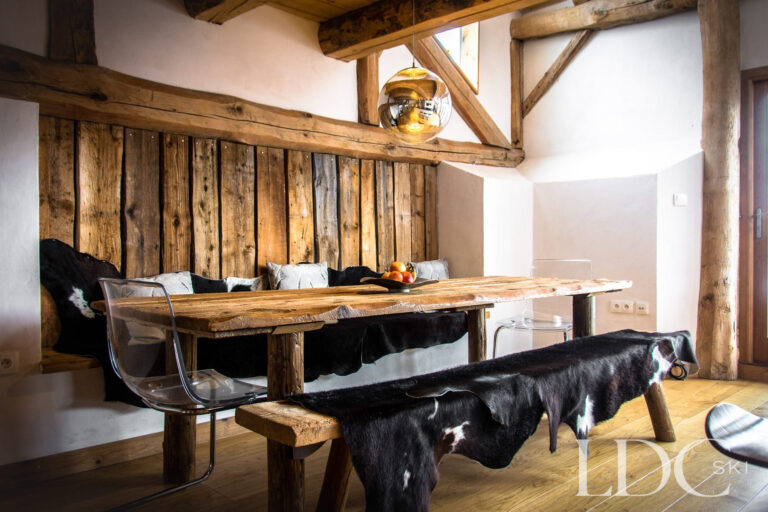 Dining area at Chalet Ann with rustic timber table, bench seating and exposed beams