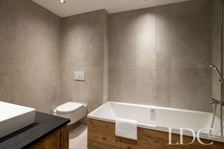 Chalet Aurea bathroom with bath and contemporary stone-effect finish