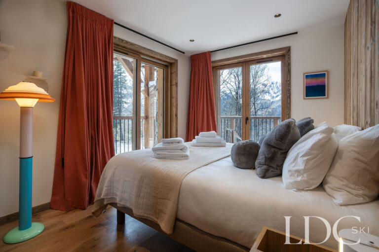 Chalet Aurea twin bedroom with large windows and contemporary furnishings
