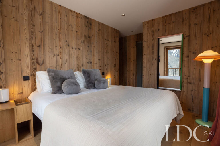 Chalet Aurea double bedroom with timber-panelled walls
