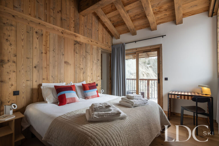 Chalet Aurea double bedroom with exposed timber and balcony access
