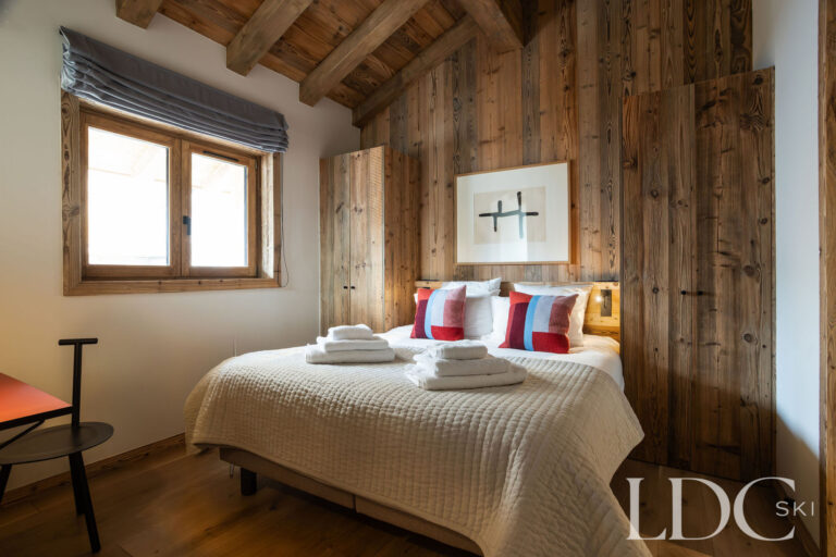 Chalet Aurea double bedroom with timber walls and alpine-style furnishings
