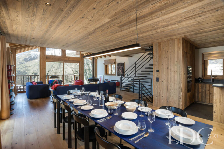 Chalet Aurea dining area leading into the lounge with floor-to-ceiling windows