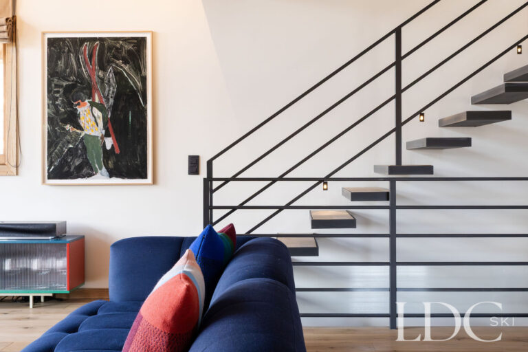 Chalet Aurea lounge with colourful seating and contemporary staircase