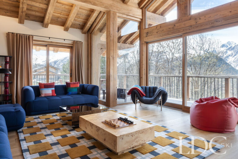 Chalet Aurea lounge with floor-to-ceiling windows and mountain views