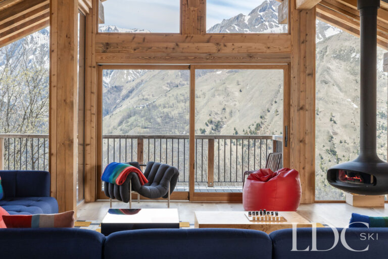Chalet Aurea lounge looking through floor-to-ceiling windows towards the mountains