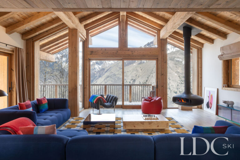 Chalet Aurea double-height lounge with vaulted timber ceiling and panoramic windows