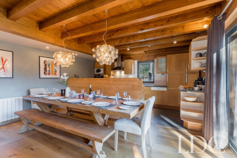 Sociable chalet dining room with exposed timber ceiling at Chalet Aux Joux