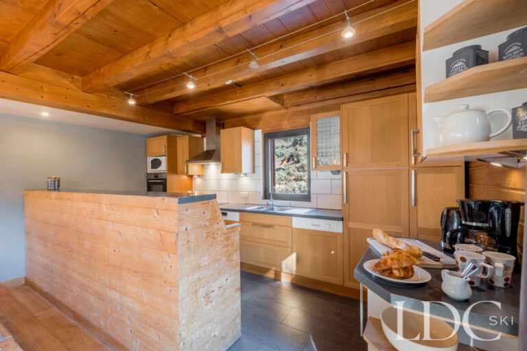 Spacious chalet kitchen with timber cabinetry at Chalet Aux Joux