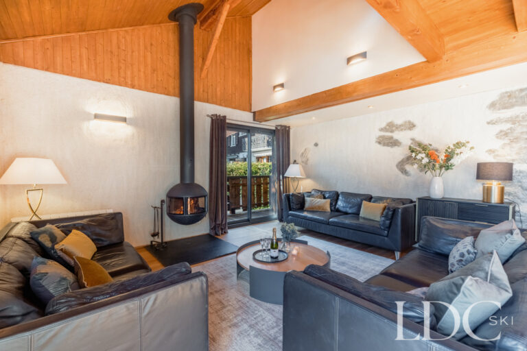 Comfortable lounge with suspended wood-burning fireplace at Chalet Aux Joux in Morzine