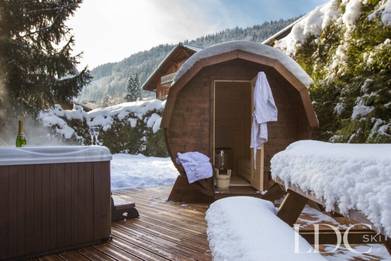 Barrel sauna in the snow-covered garden at Chalet Aux Joux in Morzine
