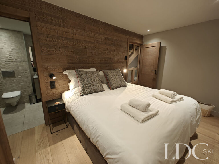 Double bedroom with windows overlooking the snowy mountains at Chalet Chardon in St Martin de Belleville