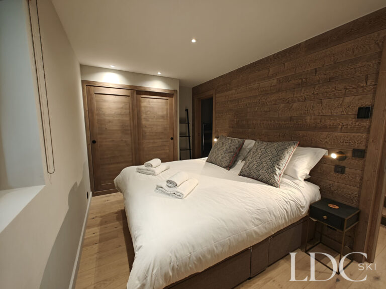 Stylish double bedroom with warm wood finishes at Chalet Chardon in St Martin de Belleville