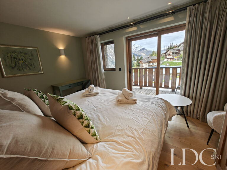 Double bedroom opening onto a balcony with mountain views at Chalet Chardon in St Martin de Belleville