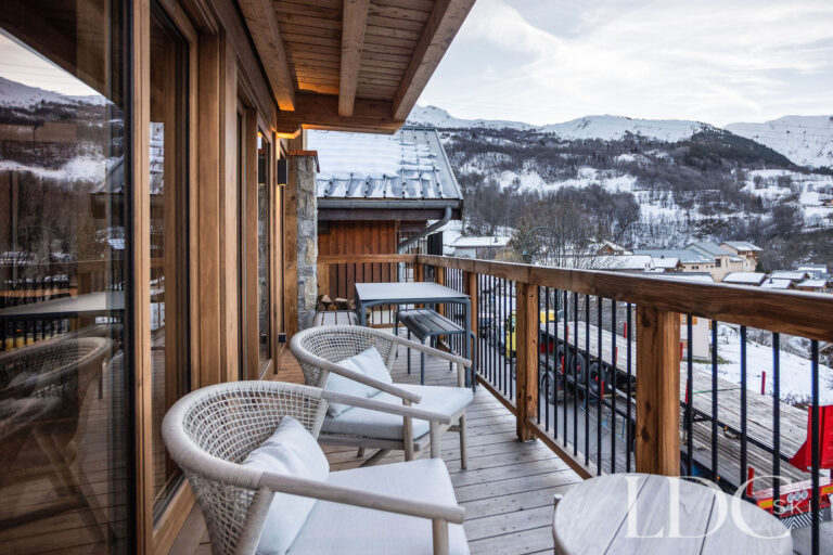 Furnished wooden balcony overlooking the snowy mountains at Chalet de Beauvoir