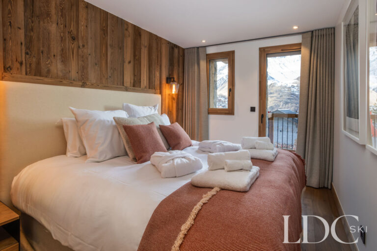 Double bedroom at Chalet de Beauvoir with wood panelling and views towards the mountains