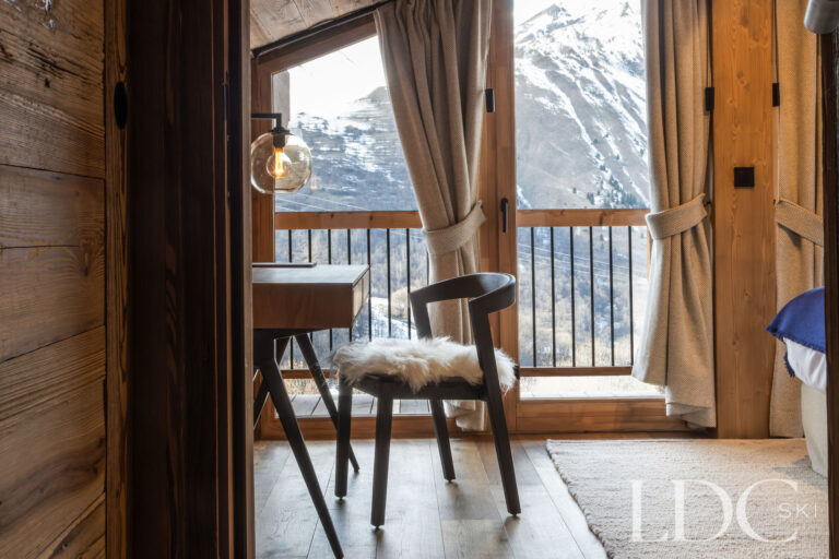 Bedroom desk beside balcony doors overlooking the mountains at Chalet de Beauvoir