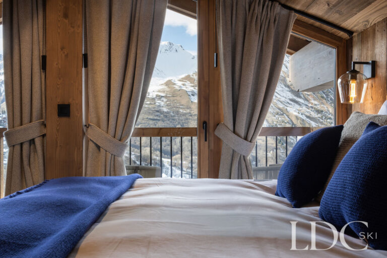 Bedroom at Chalet de Beauvoir with large windows and panoramic mountain views in St Martin de Belleville
