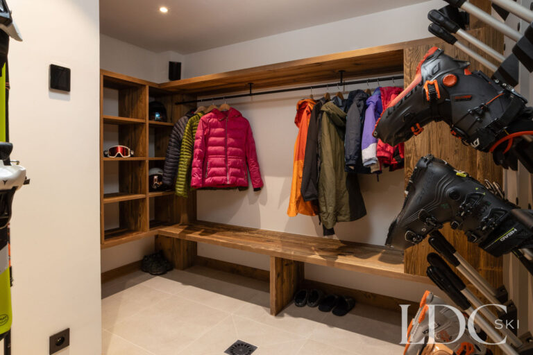 Ski and boot room at Chalet de Beauvoir with equipment storage, hanging space and wooden bench seating