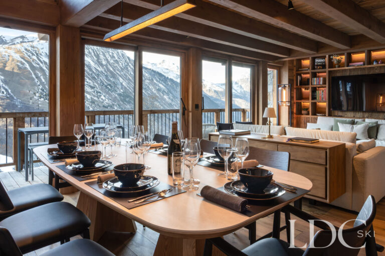 Dining area at Chalet de Beauvoir with a large table, mountain views and adjoining lounge