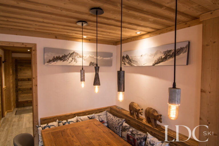 Chalet Astragle dining area with timber table, bench seating and pendant lighting