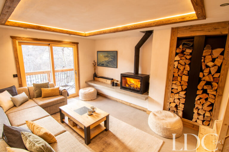 Open-plan lounge with fireplace at Chalet Camarine in St Martin de Belleville