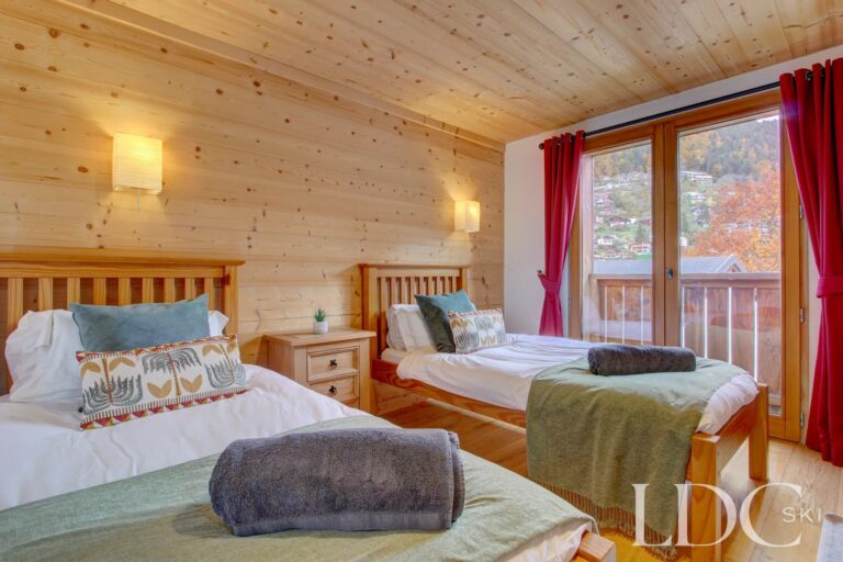 Chalet Jouet twin bedroom with timber interior and balcony access