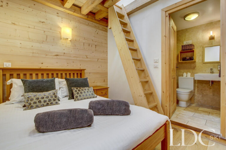 Chalet Jouet double bedroom with timber interior and ensuite shower room