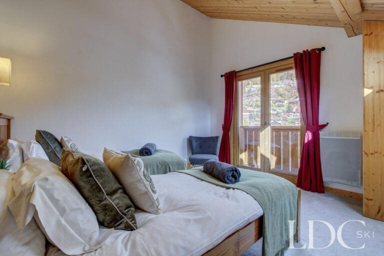 Twin bedroom at Chalet Jouet with doors opening onto the balcony