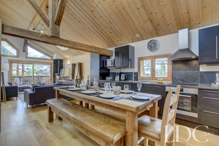 Chalet Jouet open-plan kitchen and dining area beneath a vaulted timber ceiling