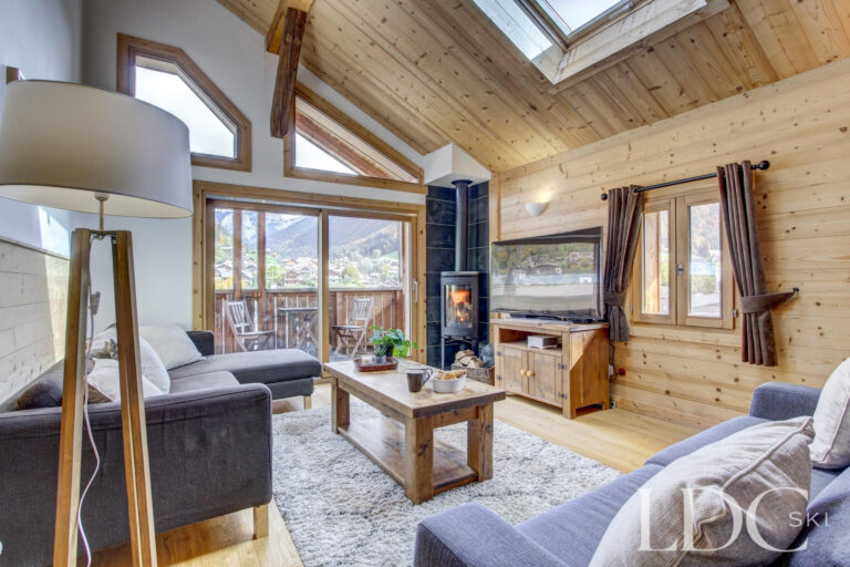 Chalet Jouet lounge with vaulted timber ceiling, fireplace and mountain views in Morzine