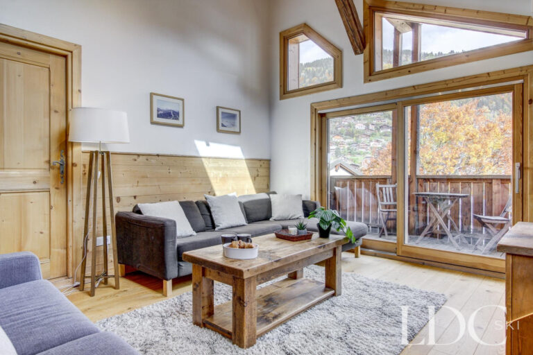 Chalet Jouet lounge with comfortable seating and doors opening onto the balcony