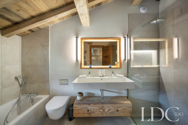 Bathroom at Chalet La Fermette with bath, walk-in shower and timber vanity unit