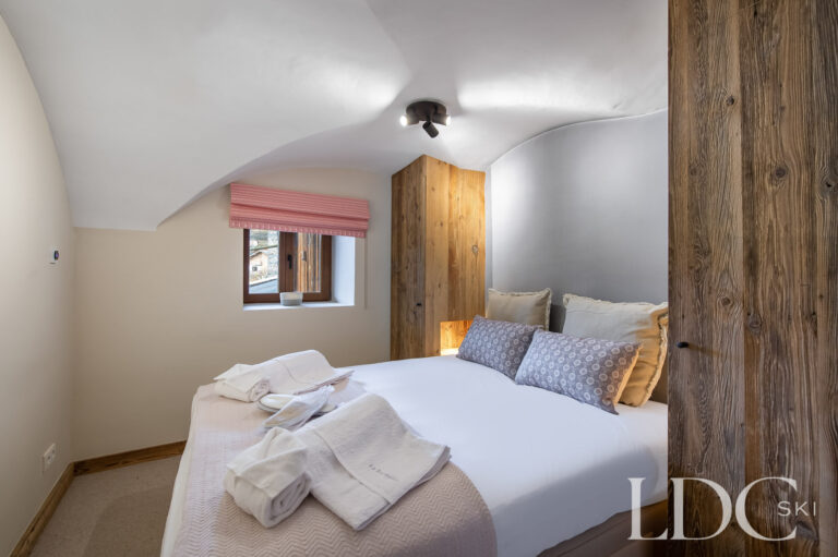 Cosy double bedroom at Chalet La Fermette with exposed timber beams
