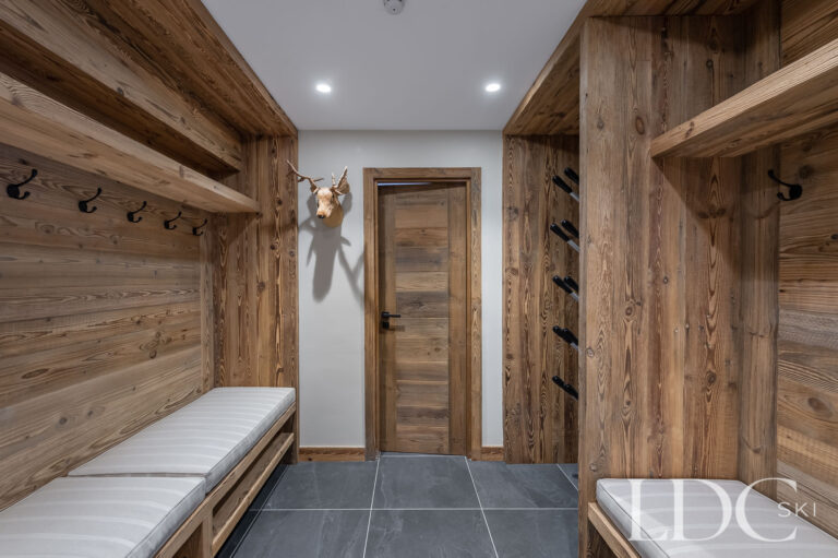 Chalet La Fermette ski and boot room with timber storage, hooks and bench seating