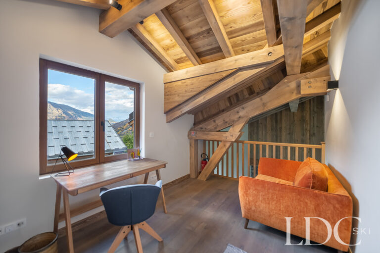 Mezzanine study at Chalet La Fermette with exposed timber beams and mountain views