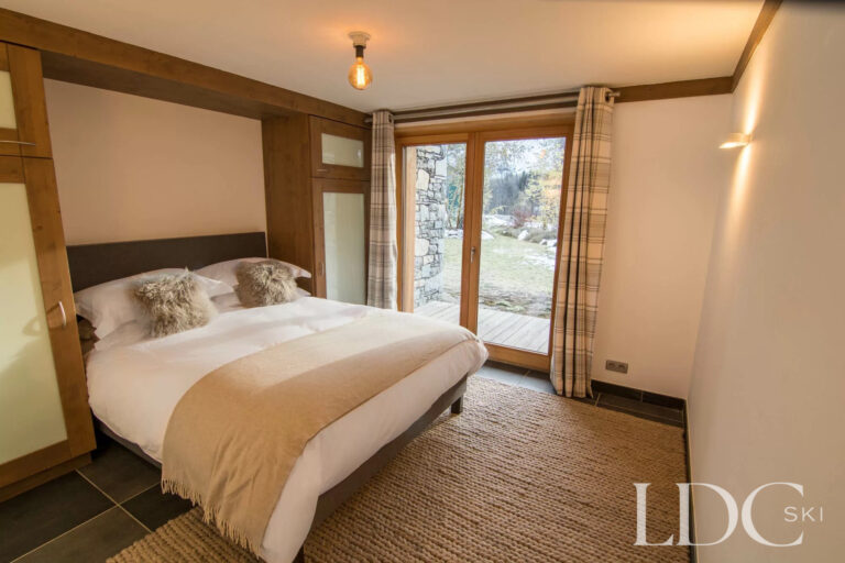 Double bedroom at Chalet Le Pic Blanc with doors opening onto the balcony
