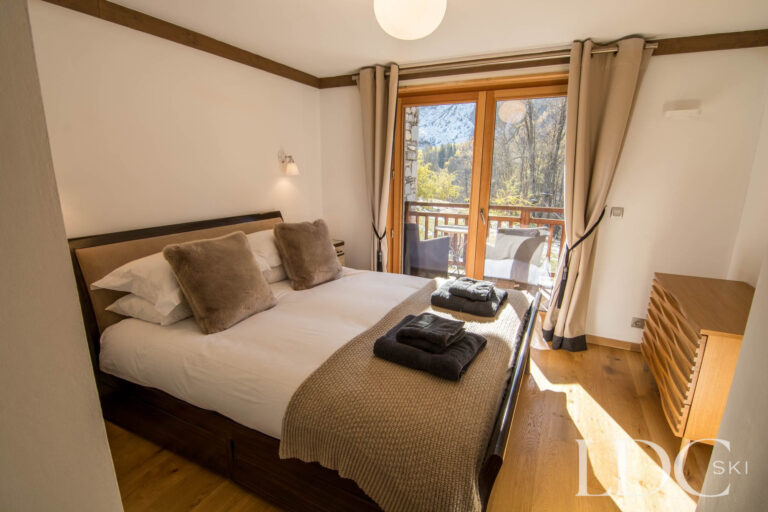 Double bedroom at Chalet Le Pic Blanc with windows overlooking the mountains