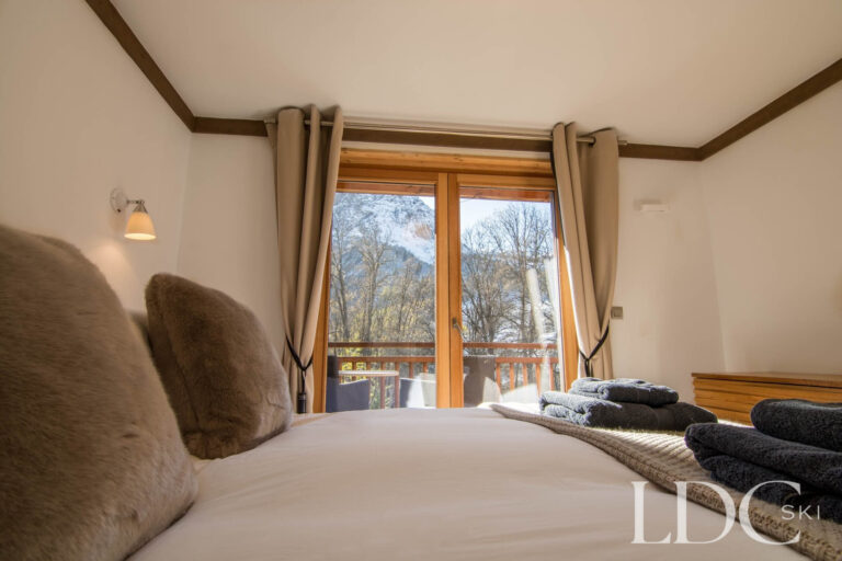 Double bedroom at Chalet Le Pic Blanc with balcony doors and mountain views