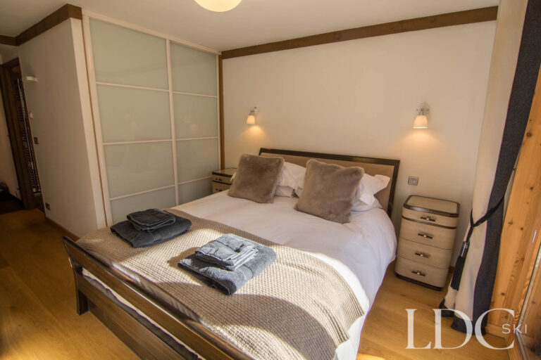 Comfortable double bedroom at Chalet Le Pic Blanc with fitted storage