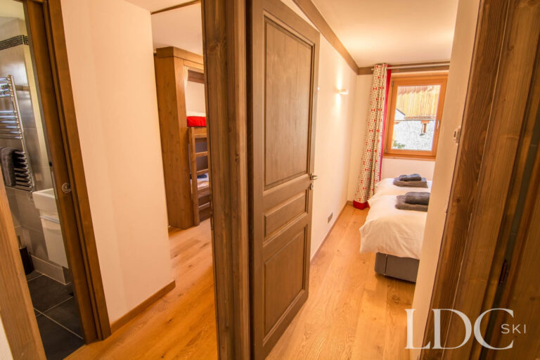 Bedroom and hallway at Chalet Le Pic Blanc with traditional timber doors