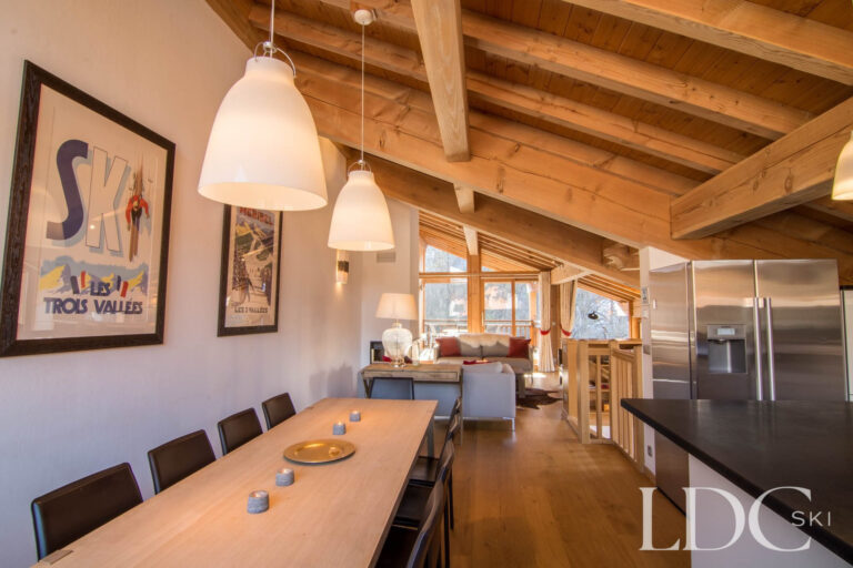 Open-plan dining area at Chalet Le Pic Blanc with large table and exposed timber ceiling