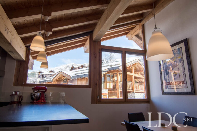 Dining area at Chalet Le Pic Blanc with windows overlooking the surrounding mountains