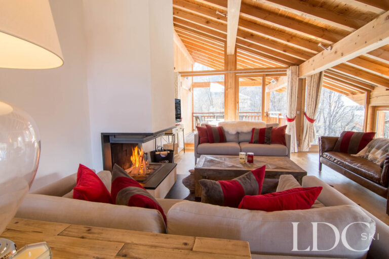 Chalet Le Pic Blanc lounge with comfortable sofas, log fire and exposed timber beams